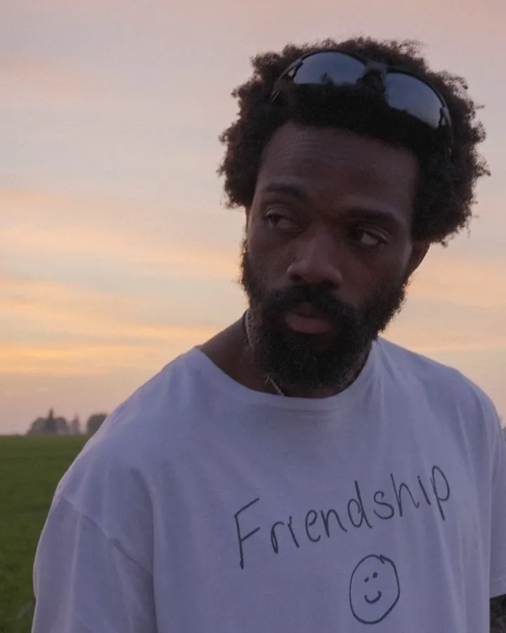 Deelo Avery at dusk wearing a hand-lettered Friendship T-shirt